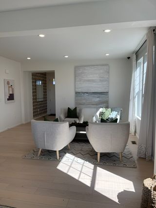 A cozy living room with modern armchairs, soft lighting, and abstract art, creating a serene and welcoming atmosphere.