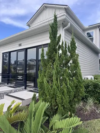 A chic modern home with sleek gray siding and lush landscaping in RiverTown - Meadows by Mattamy Homes (St. Johns, FL).
