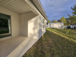 A cozy outdoor corner with a lush backyard in Marion Oaks by Century Complete (Ocala, FL).