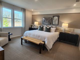 A serene bedroom with a cozy bed, stylish nightstands, and soft natural lighting.