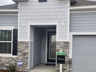 Charming gray home with stone accents and modern design in Creekside Landing by Maronda Homes (Callahan, FL).