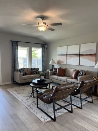 A cozy living room with modern sofas, stylish armchairs, and decorative art, featuring a plush rug and ambient lighting.