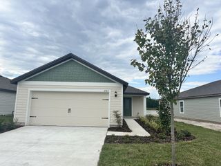 A charming home with a gabled roof and landscaped front yard in Westport Landing by LGI Homes (Jacksonville, FL).