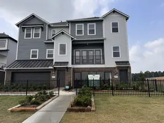 Street view A modern multi-story home with sleek siding and a fenced yard in Townsen Landing by Saratoga Homes (Humble, TX).