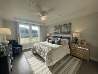 A cozy bedroom with elegant décor, a plush bed, large windows, and warm lighting, creating a serene and inviting atmosphere.