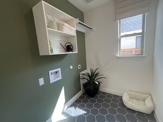 A functional laundry room with sleek storage, modern hexagonal flooring, and natural light.
