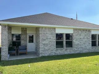 A charming brick home with a cozy porch in Laurel Landing by Coventry Homes (Alvin, TX).