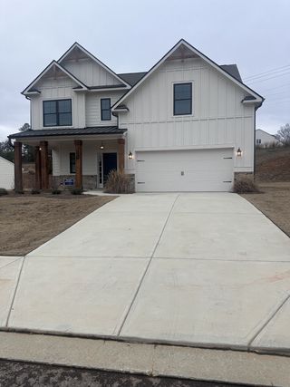 A charming white-paneled home with a spacious driveway in The Reserve at Chapel Hill Phase II by Kerley Family Homes (Douglasville, GA).