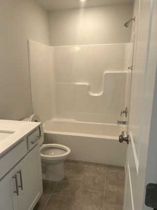 A sleek bathroom featuring a built-in tub, stylish vanity, and modern fixtures for a relaxing and functional space.
