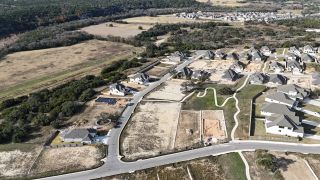 An aerial view of the Crescent Bluff neighborhood by Scott Homes (Georgetown, TX), showcasing homesites, winding roads, and natural surroundings.