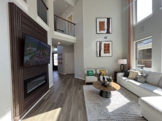 An elegant two-story living room with a statement fireplace and open-concept layout in Solterra by Chesmar Homes (Mesquite, TX).
