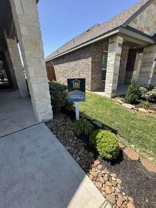 A charming brick home with stone accents and landscaped entry in Wedgewood Forest by LGI Homes (Conroe, TX).
