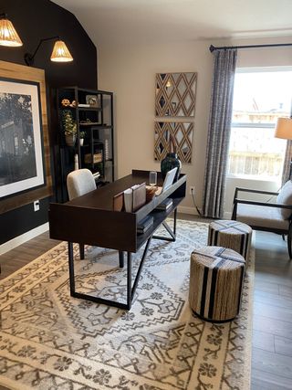 Model Home A contemporary home office with a sleek desk, patterned rug, and ambient lighting creates a cozy and productive space.