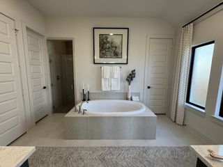 Bathroom: A spa-like primary bathroom with a luxurious soaking tub and glass shower.