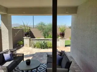 A serene patio with cozy seating, contemporary planters, and a scenic mountain view in the background.
