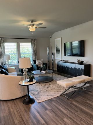 A modern living room featuring sleek furniture, elegant lighting, and a cozy ambiance with natural light streaming in.
