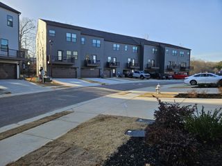 Street view Modern townhomes with sleek gray exteriors and driveways in Village Towns by Ryan Homes (Fayetteville, GA).