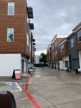 Street view Modern townhomes with sleek wooden exteriors in Bluebonnet Lofts by InTown Homes (Austin, TX).