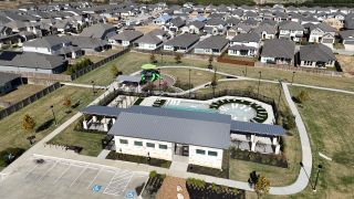 Community Amenities Aerial view of community amenities with a playground and pool in Turner's Village by Meritage Homes, Buda, TX.