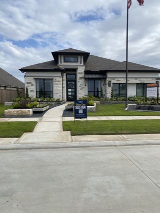 Street view A modern stone home with manicured landscaping in Valencia 45' by Perry Homes (Manvel, TX).