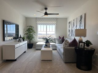 Model Home A modern living room with neutral tones, stylish decor, abundant natural light, and cozy seating arrangements.