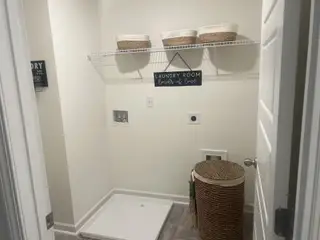 A cozy laundry room with woven baskets, a wall shelf, and a chic hamper, creating a functional and stylish space.