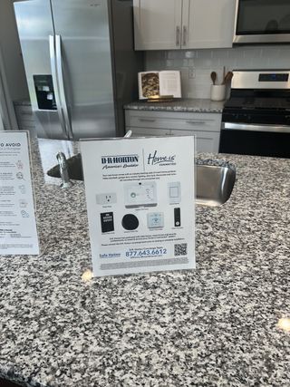 Model Home A modern kitchen with granite countertops, stainless steel appliances, and elegant cabinetry.