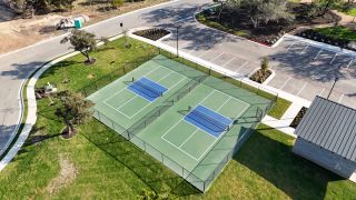 A drone-captured image of the community's recreational facilities, featuring two well-maintained courts enclosed by fencing, providing an ideal space for outdoor sports enthusiasts.