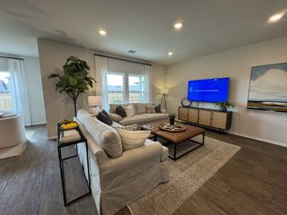 A modern living area with a neutral color palette, elegant furniture, and an open layout connecting to the dining and kitchen spaces.