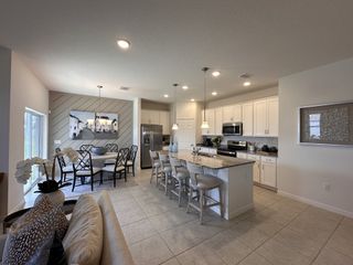 An elegant open-plan kitchen with a central island, granite countertops, and contemporary dining area.