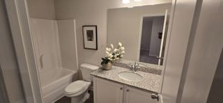 Model Home A modern bathroom featuring a granite countertop, elegant white cabinets, and fresh decor.