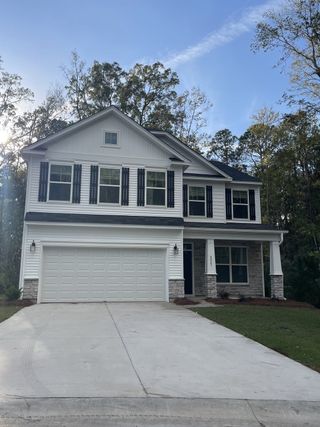 A charming two-story white siding home with a double garage in Magnolia Pointe by Eastwood Homes (North Charleston, SC).