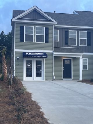 Modern townhouse with gray siding and shutters in Pine Hills Townhomes at Cane Bay by D.R. Horton (Summerville, SC).