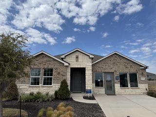 Street view A charming stone and brick home with landscaped front yard in Firefly Pointe: Stonehill Collection by Lennar (Hutto, TX).