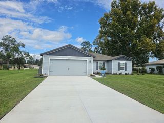 A charming gray home with a spacious driveway and lush lawn in Marion Oaks by LGI Homes (Ocala, FL).
