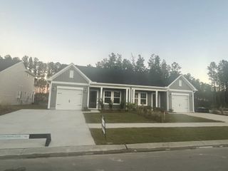 Street view A charming gray home with a welcoming porch and a neatly landscaped yard in Hammock Walk at Nexton by Ashton Woods (Summerville, SC).