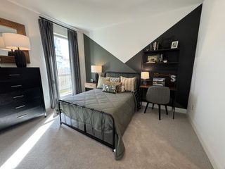 A chic bedroom featuring geometric accent walls, modern furniture, and natural light from a large window with elegant drapes.