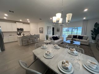 Open-concept living area with modern kitchen, elegant dining setup, and cozy seating, perfect for entertaining.