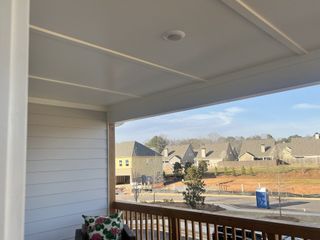 A charming porch view of new homes in Wilkins Walk by Traton Homes, Mableton, GA, showcasing community development.