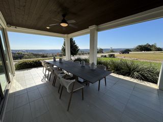 A picturesque covered patio with panoramic hill country views, perfect for outdoor dining and relaxation.