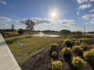 Scenic pond view with lush landscaping in Marvida Trails South by KB Home, located in Cypress, TX.
