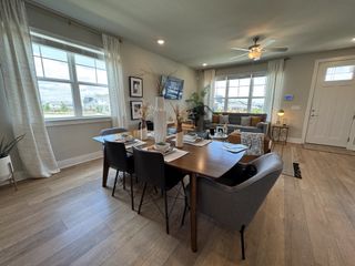 A modern dining and living area with large windows, wood floors, and stylish decor. Cozy yet spacious ambiance.