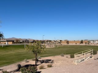 Community Amenities Expansive green parkland with desert landscaping in The Lakes at Rancho El Dorado by Brightland Homes (Maricopa, AZ).