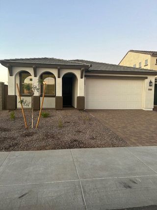 Street view A charming home with arched entryways and a spacious garage in Allen Ranches: Fiesta Collection by Taylor Morrison (Litchfield Park, AZ).
