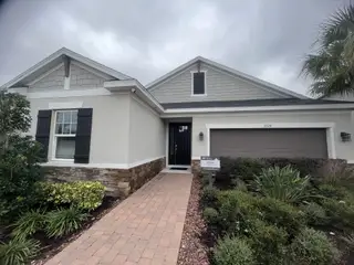 A charming home with stone accents and lush landscaping in River Landing by Taylor Morrison (Wesley Chapel, FL).