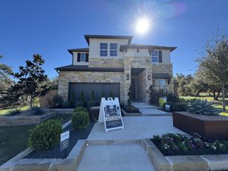 A beautiful stone-front home with manicured landscaping in Retreat at San Gabriel by Tri Pointe Homes (Georgetown, TX).