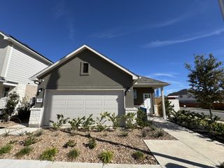 A modern home with a sleek garage and landscaped yard in Lariat by Landsea Homes (Liberty Hill, TX).