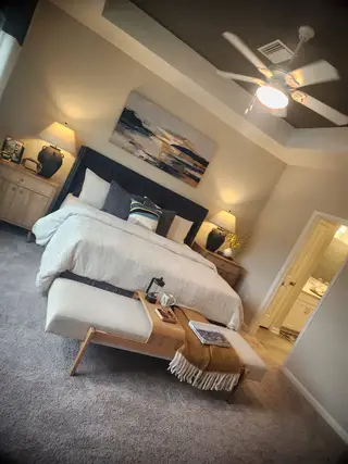 Model Home A cozy bedroom featuring a stylish bed, elegant lighting, and modern artwork, providing a serene retreat.