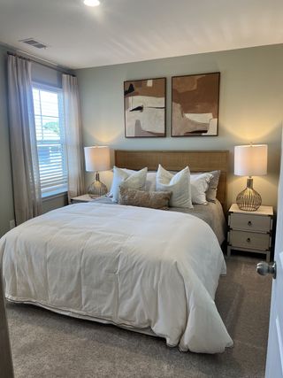 A cozy bedroom with abstract art, plush bedding, and soft lighting creating a serene and inviting atmosphere.