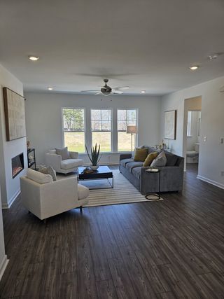 Model Home A cozy living room featuring a sleek fireplace, plush seating, and natural light from large windows.